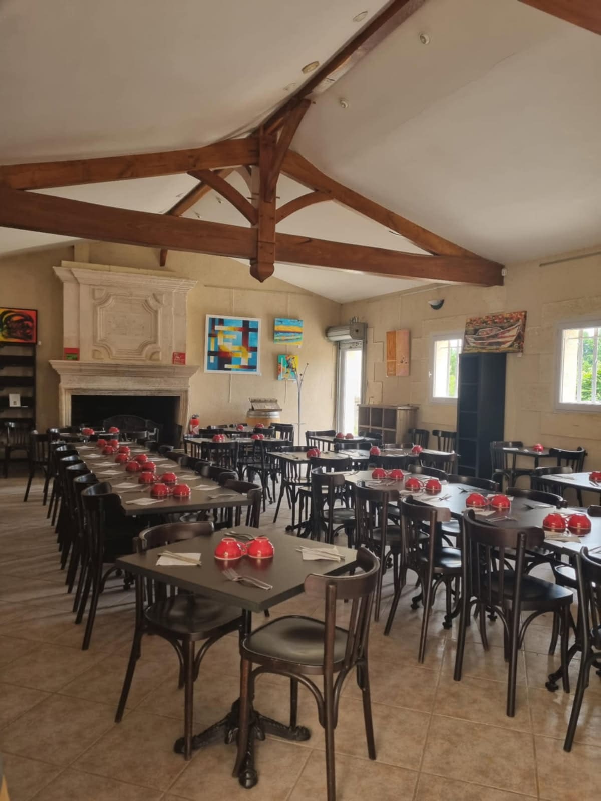 La salle sous la charpente apparente, tables dressées